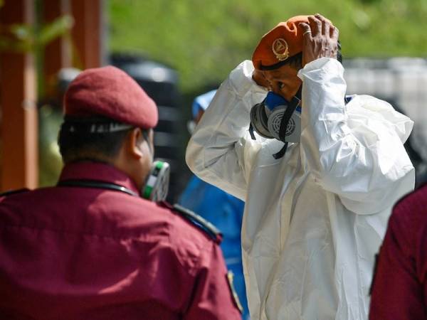 Pasukan Unit HazMat (Bahan Berbahaya) Angkatan Pertahanan Awam turut melakukan persiapan sebelum ke lokasi insiden pencemaran bahan kimia di Pusat Kawalan Lapangan (Ground Command Centre) Dewan Komuniti Taman Pasir Putih Pasir Gudang hari ini. - Foto Bernama