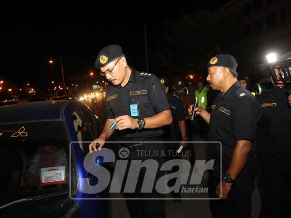 Zulkarnain sedang melakukan pemeriksaan ke atas pemandu, dalam Ops Khas Bersepadu di Jalan Sultan Mohamad, di sini, malam tadi.
