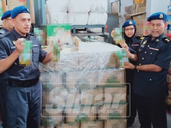 Suhaimi (dua, kiri) menunjukkan tepung gandum yang disita dari sebuah gudang yang dipercayai melakukan penyelewengan barang kawalan bersubsidi di Teluk Intan, semalam.