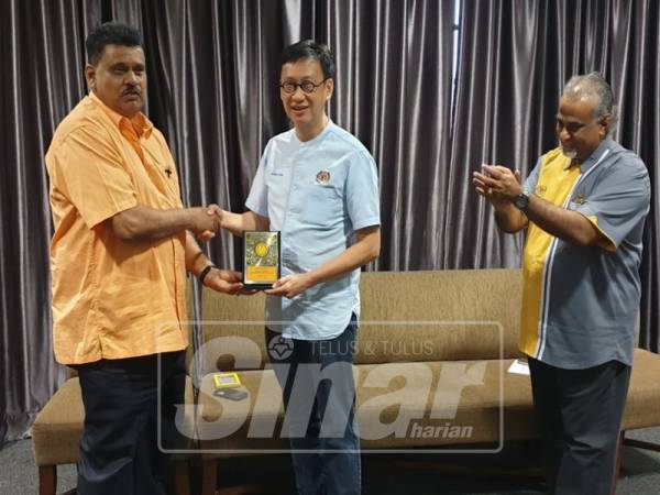 Mohamad Haron (kiri) menyampaikan cenderahati kepada Wong Chen selepas majlis perasmian.