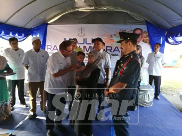 Wan Rosdy beramah mesra bersama Noor Nadia dan Muhammad Meqa ketika menyampaikan sumbangan RM10,000 pada Majlis Ramah Mesra Bersama Nelayan Beserah di pekarangan Pusat Pengisytiharan Kampung Beserah Pantai.