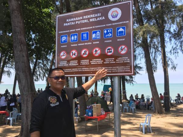 ADUN Kawasan Pantai Kundor, Datuk Nor Azman Hassan menunjukkan salah satu papan tanda larangan yang dipasang sejak hampir seminggu lalu di sepanjang Pantai Puteri.