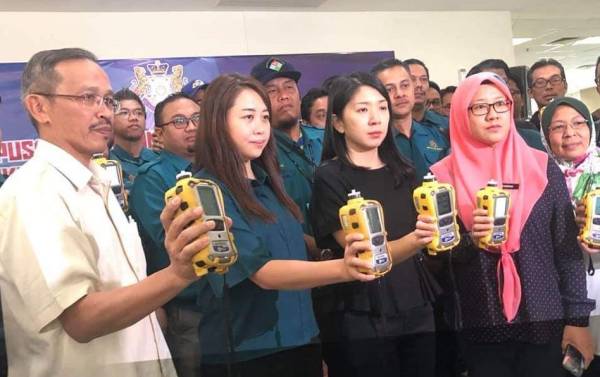 Bee Yin (dua, kanan) menunjukkan alat pengesan gas yang digunakan untuk memantau udara. Foto: Twitter Yeo Bee Yin.