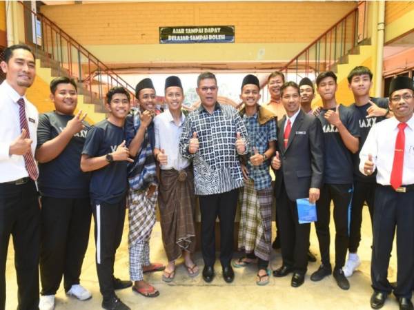 Menteri Perdagangan Dalam Negeri dan Hal Ehwal Pengguna Datuk Seri Saifuddin Nasution Ismail bergambar bersama sebahagian ahli-ahli Persatuan Vmaxx Production dan guru SMK Pokok Sena selepas merasmikan Mesyuarat Agung Tahunan PIBG kali ke-47 SMK Pokok Sena hari ini. - Foto Bernama