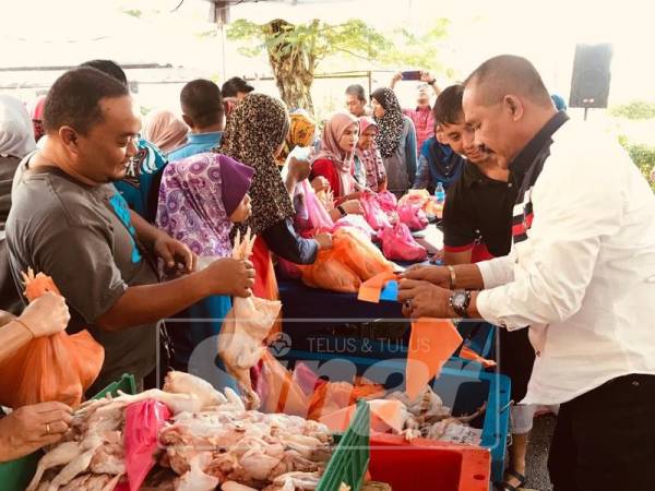 Abu Bakar Yahya menjual ayam kepada orang ramai sempena Program Pasar Jualan Jimat Harapan Rakyat di perkarangan kawasan Perumahan Awam Seri Perlis 2, Kuala Lumpur, hari ini.
