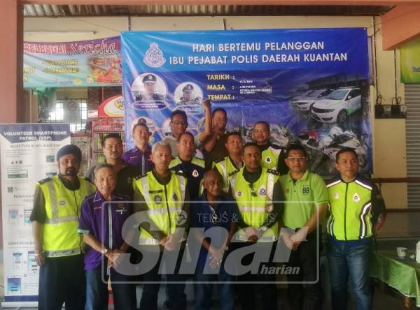 Mohamad Noor (tiga, kanan) dan Abdul Aziz (tiga, kiri) bersama sebahagian IPD polis bergambar selepas menyampaikan poster pencegahan jenayah.