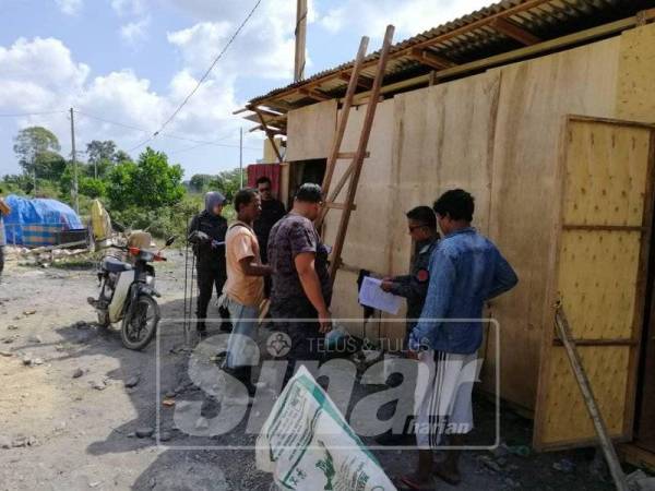 Anggota imigresen membuat pemeriksaan di Kampung Kubang Bujuk, Kuala Terengganu.