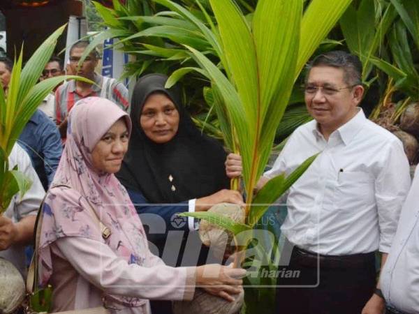 Salahuddin (kanan) menyerahkan benih pokok kelapa kepada penerima.