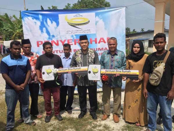 Maskeris (dua, kanan), Mohd Zulkifli (tiga, kanan), Zainalinopis (kiri) bergambar bersama Pegawai Tadbir Agama Daerah Hilir Perak, Mustapa Jaafar selepas simbolik serahan kunci rumah yang diterima mereka.