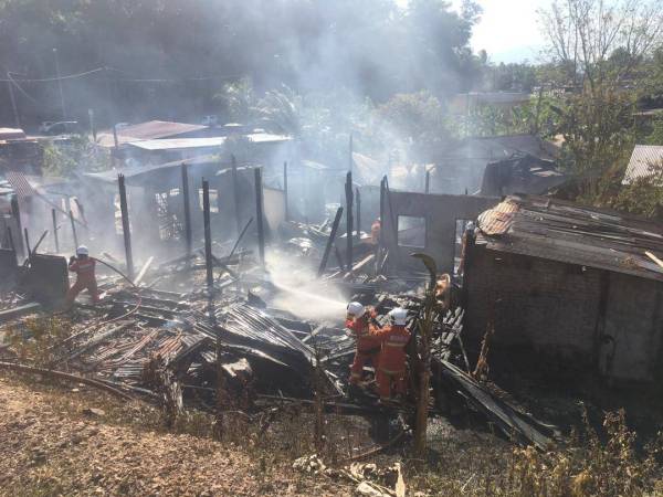 Anggota bomba bertungkus memadam kebakaran yang melibatkan dua buah rumah di Bandar Setiu.