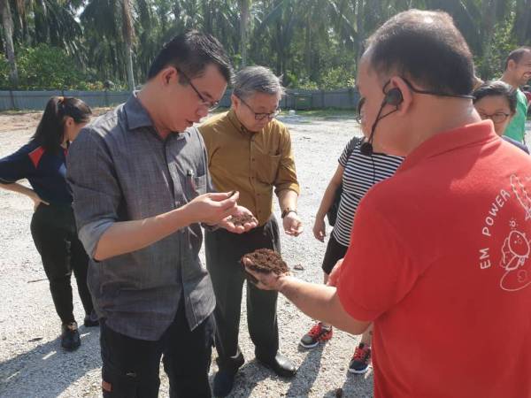 Hong Pin (kiri) melihat sisa buangan yang diproses di Ladang FOLO, di sini, hari ini.