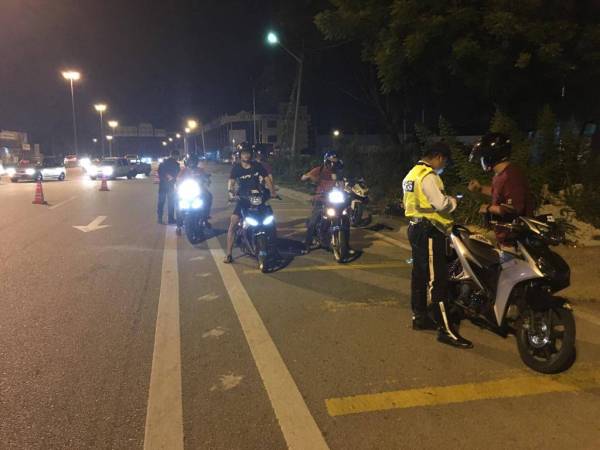 Anggota polis memeriksa motosikal pada operasi yang dilakukan semalam.