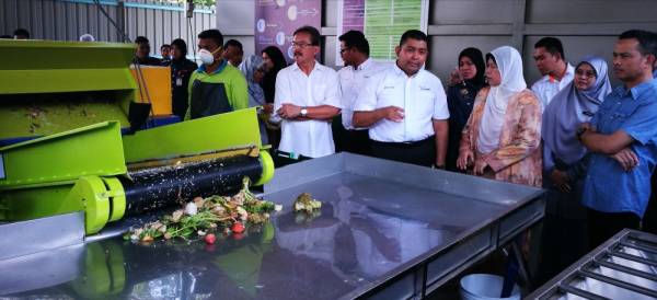 Zuraida (tiga, kanan) mendengar penerangan Ir Mhd Saiful Anuar (dua, kiri) berhubung operasi mesin pengasingan dan pemprosesan sampah.