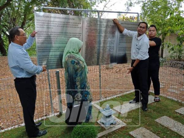 Mohd Asmirul Anuar (dua, kanan) menurunkan papan maklumat tertera perkataan wira.