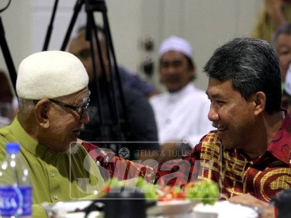 Mohamad berbual mesra dengan Abdul Hadi pada majlis makan malam yang diadakan, di sini, malam tadi. -Foto Syamilah Zulkifli