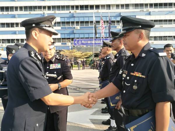 Yusri (kiri) bersalaman dengan anggota polis Pahang yang menerima Sijil Penghargaan atas khidmat cemerlang pada Sambutan Peringatan Hari Polis Ke-212 Tahun 2019 di Pekarangan Ibu Pejabat Polis Kontinjen (IPK) Pahang di sini, hari ini.