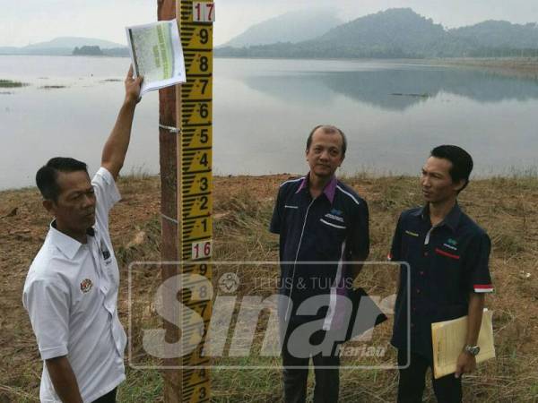 Kamal (kiri) bersama pegawainya ketika meninjau keadaan paras air di empangan Bukit Kwong, Lubok Stol yang ketika ini berada pada tahap serius.