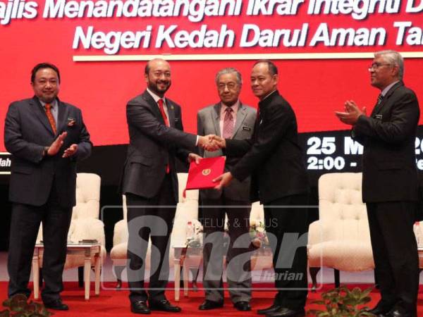 Tun Mahathir (tengah) menyaksikan penyerahan ikrar integriti dan bebas rasuah Kedah oleh Mukhriz kepada Ketua Pesuruhjaya SPRM, Datuk Seri Mohd Shukri Abdull.