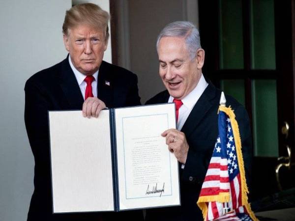 Trump (kiri) dan Netanyahu menunjukkan deklarasi mengiktiraf kedaulatan rejim Israel ke atas Bukit Golan. - Foto AFP
