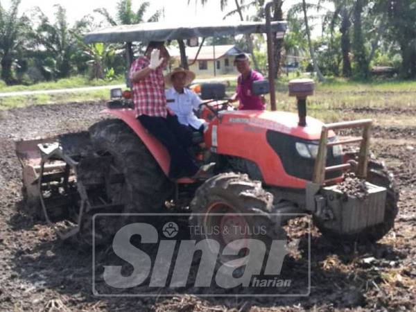 Nadzri (tengah) menerima cenderahati daripada wakil PPK Selinsing dan Gunong Semanggol, Abdul Rahman (dua, kiri).