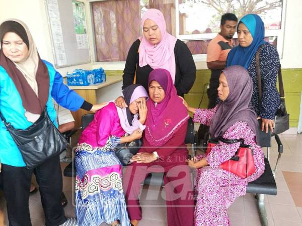 Nor Hasidah cuba menenangkan besannya, Selmor Salleh yang tidak dapat menahan air mata setelah mendapat tahu anak dan cucu mereka meninggal dunia akibat kemalangan di Kilometer 55, Jalan Nenasi-Rompin, dekat Kampung Badong, di sini, hari ini.