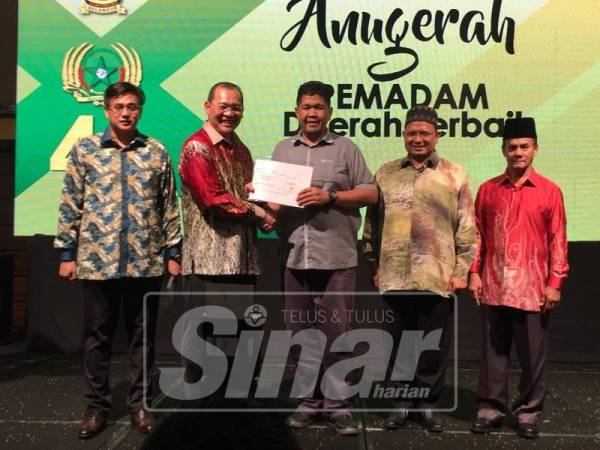 Pengerusi Jawatankuasa Tetap Pembangunan Generasi Muda, Sukan dan Pembangunan Modal Insan Kerajaan Selangor yang mewakili Menteri Besar Selangor, Mohd Khairuddin Othman menyampaikan anugerah kepada Mohd Fakhzan (tengah). 