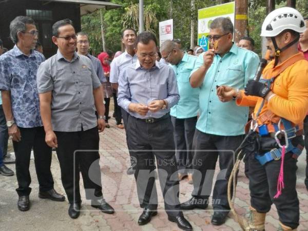 Osman (tiga, kanan) melihat buah-buahan hutan yang terdapat di Taman Eko Rimba Gunung Belumut, Kluang.