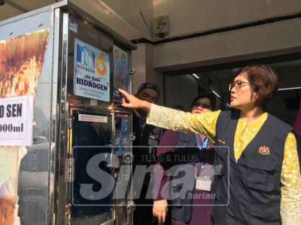 Lay Ming menunjukkan mesin jual air di kaki lima premis di Taman Bercham Baru yang mempunyai lesen, selamat untuk digunakan oleh pengguna.