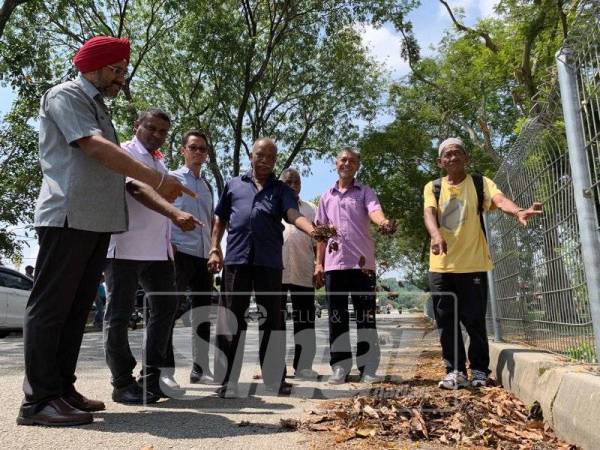 Penduduk menunjukkan keadaan sampah daun kering yang sudah menutupi saliran air.