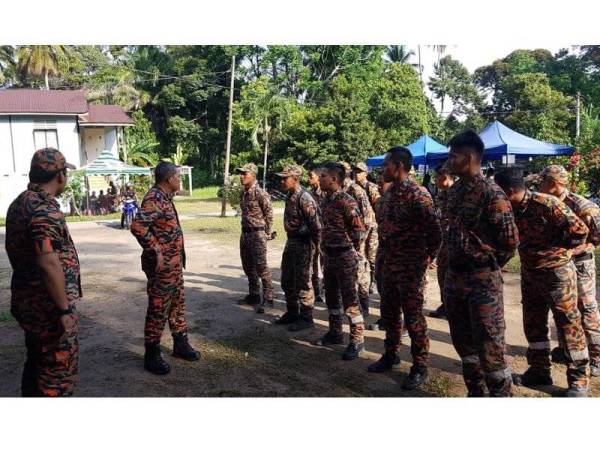 Anggota bomba mendengar taklimat daripada Yunus (dua, kiri) sebelum memulakan pendakian bagi mencari Acap, hari ini. 