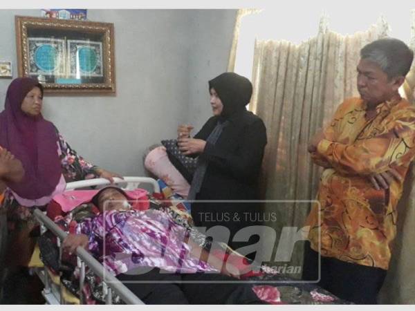 Keen Tong (kanan) dan Jawiyah (dua, kanan) hadir menyampaikan barangan sumbangan dan keperluan kepada Marina yang terlantar di Kampung Keda Semeliang, Kuala Nerang