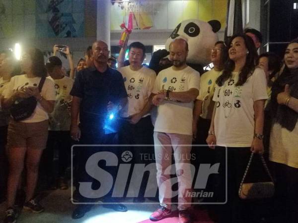 Mukhriz(tengah) menunggu detik lampu dimatikan sempena Earth Hour.