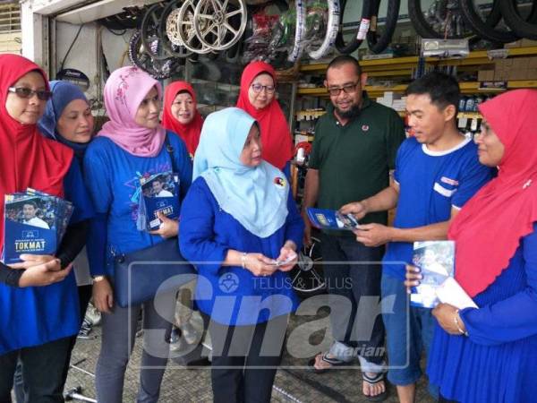 Salbiah (tengah) mengedarkan risalah kempen kepada pengundi DUN Rantau