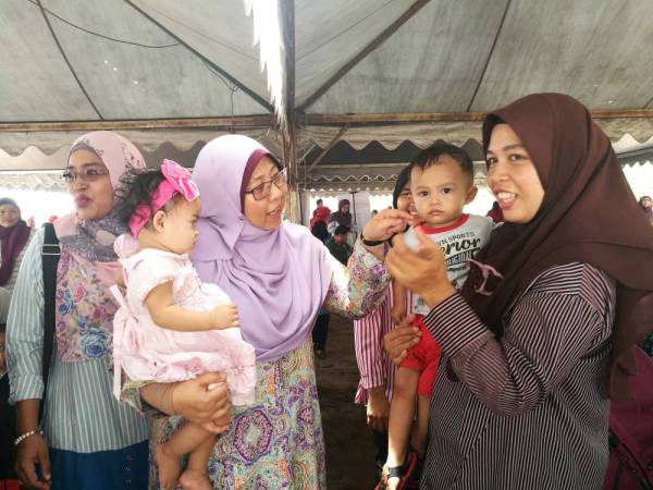 Fuziah beramah mesra bersama ibu dan wanita yang hadir pada Program Sambutan Hari Wanita di Pantai Cherok Paloh di sini, hari ini.