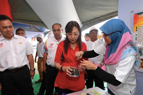 Menteri Industri Utama Teresa Kok (dua, kanan) diberikan taklimat mengenai benih klon sawit oleh Eksekutif Kanan Sawit Kinabalu Sdn Bhd Rohani Munir (kanan) ketika melawat ruang pameran selepas mengadakan lawatan ke Pusat Konservasi Sungai Pin hari ini. -Foto Bernama