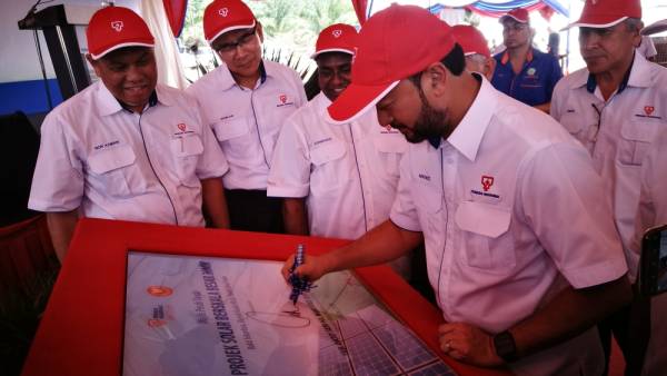 Mukhriz menurunkan tandatangan sebagai gimik pelancaran Majlis Pecah Tanah LSS di Pekan Bukit Selambau, hari ini.