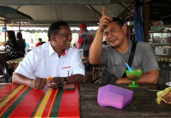 Dr S. Streram (kiri) beramah mesra bersama penduduk setempat pada Majlis Santai Bersama Penduduk Felda Sendayan hari ini. -Foto Bernama