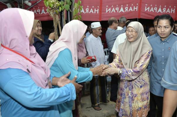 Dr Wan Azizah beramah mesra dengan sebahagian para hadirin ketika membuat lawatan di Kampung Sri Lalang sempena PRK DUN N27 Rantau hari ini. -Foto Bernama