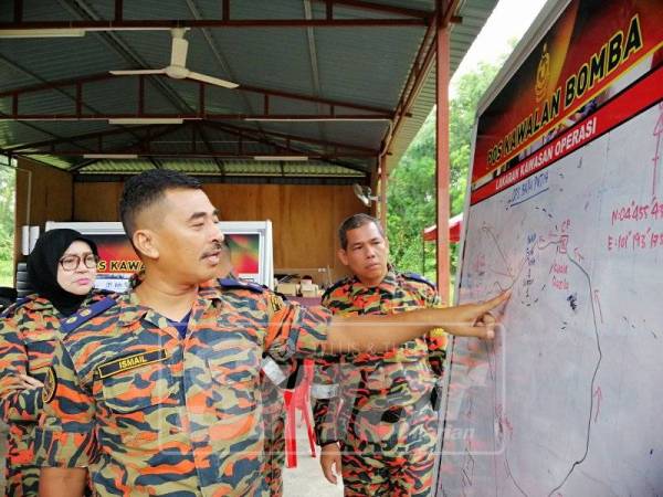 Ismail menunjukkan tumpuan dua lokasi pencarian Strom ketika ditemui di Pos Kawalan Bomba di Kampung Pintu Padang, hari ini.