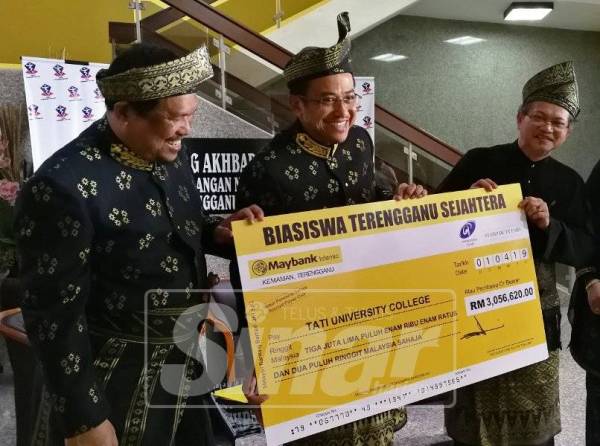 Ahmad Samsuri (tengah) menyerahkan replika cek tajaan biasiswa kepada Profesor Dr Anuar (kanan).