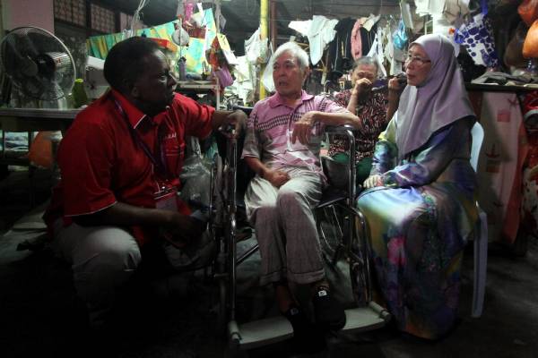 Dr Wan Azizah (kanan) ketika menziarahi pesakit angin ahmar Au Moi @ Au Peng Kan, 80, di rumahnya di Kampung Kuala Sawah ketika berkempen sempena PRK DUN N27 Rantau, hari ini. -Foto Bernama