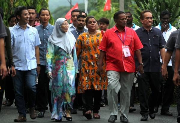 Dr Wan Azizah (tiga, kiri) mengadakan lawatan ke beberapa buah rumah di Kampung Kuala Sawah ketika berkempen sempena PRK DUN N27 Rantau hari ini. Turut hadir calon PH Dr S Streram (tiga, kanan). -Foto Bernama