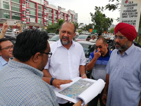 Gobind mendengar penjelasan dari pegawai JPS yang berada di lokasi. 