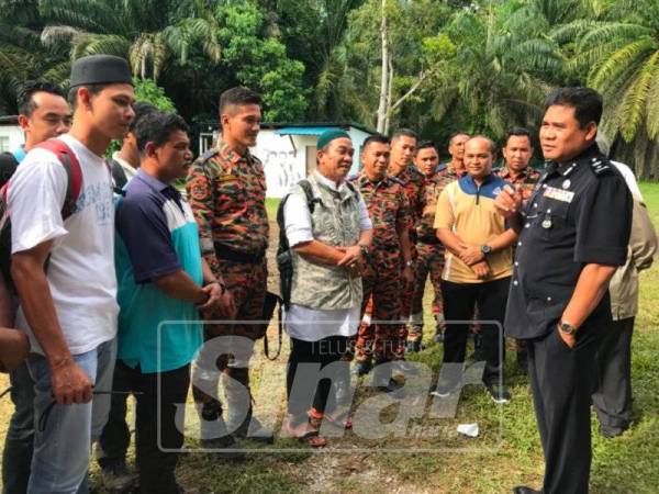 Yahya (kanan) menyampaikan taklimat kepada pasukan daripada Ibu Pejabat Polis Kontinjen Perak yang turut serta membantu mencari Acap, hari ini.