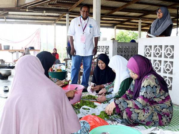 Dr Streram (tengah) beramah mesra dengan kaum ibu yang menyediakan masakan pada program gotong royong membersihkan kawasan masjid Kampung Siliau sempena kempen PRK DUN Rantau, semalam. - Foto Bernama