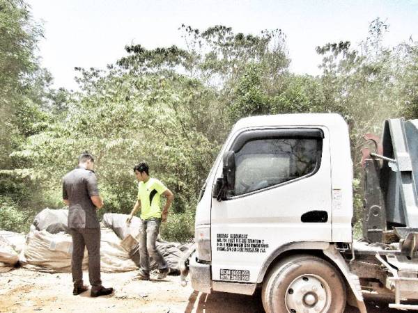 Pegawai penguatkuasa Perbadanan SWCorp menahan sebuah lori yang cuba membuang sampah di tapak pelupusan haram di Kampung Bukit Nangka di sini, hari ini.