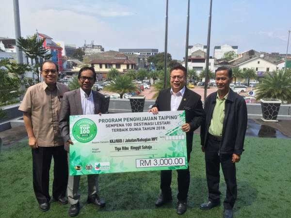 Abdul Rahim (dua, kanan) menerima replika cek sumbangan RM3,000 dari wakil ketua jabatan, ketua bahagian dan seluruh warga MPT bagi penanaman 1,000 pokok di bandar Taiping.