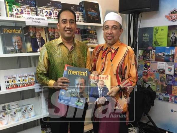 Najmi (kiri) bersama salah seorang pengunjung di reruai Jabatan Penerangan PBAKL. 