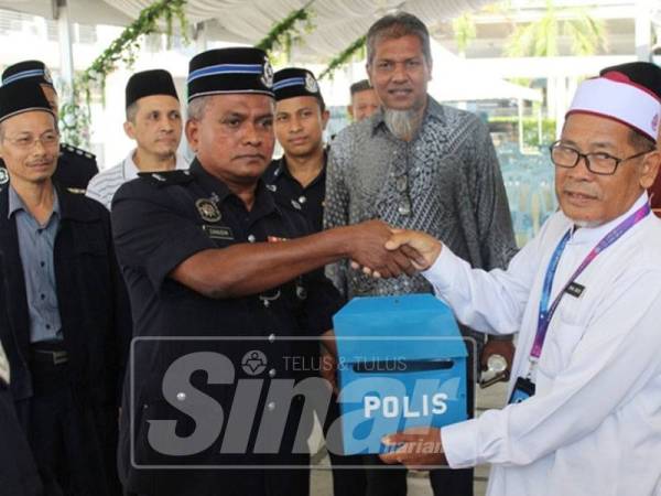 Zainudin (kiri) menyerahkan peti polis kepada wakil Pengerusi Masjid Puncak Alam, Zainal Abidin Sulaiman sebagai simbolik Pelancaran 1M1P.