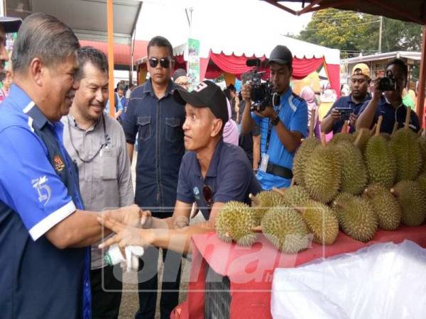 Mohamad (kiri) bersalaman dengan salah seorang peniaga yang menyertai Karnival SAM @ My Best Buy Parlimen Kota Raja, di Stesen Mardi Jalan Kebun.